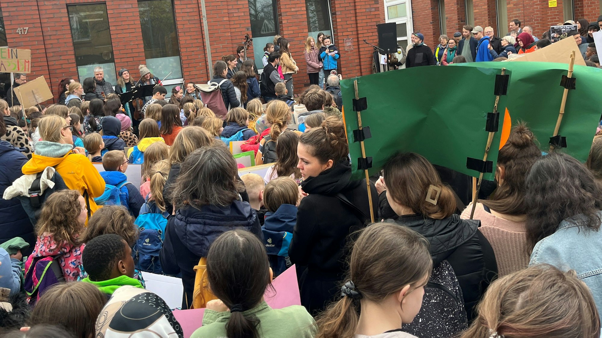 Eine Menschenmasse, bestehend aus Kindern, hält Plakate hoch.