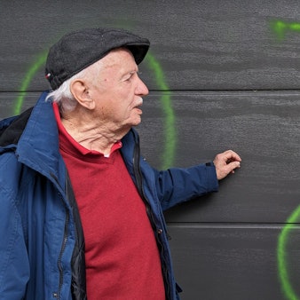 Peter und Rosemarie Leister aus Bad Münstereifel-Mahlberg stehen fassungslos vor ihrem Garagentor, das mit grüner Signalfarbe beschmiert worden ist.