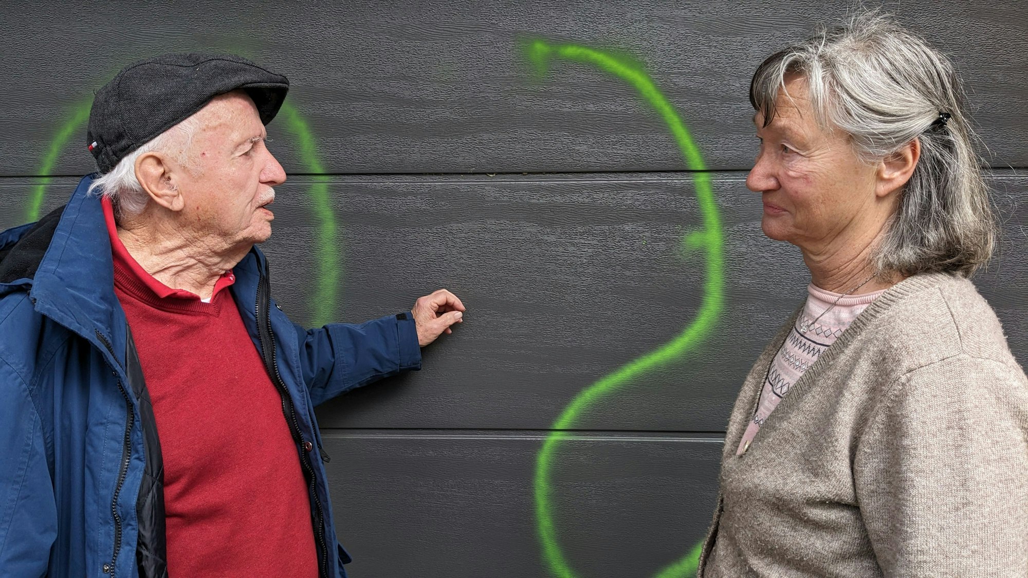 Peter und Rosemarie Leister aus Bad Münstereifel-Mahlberg stehen fassungslos vor ihrem Garagentor, das mit grüner Signalfarbe beschmiert worden ist.