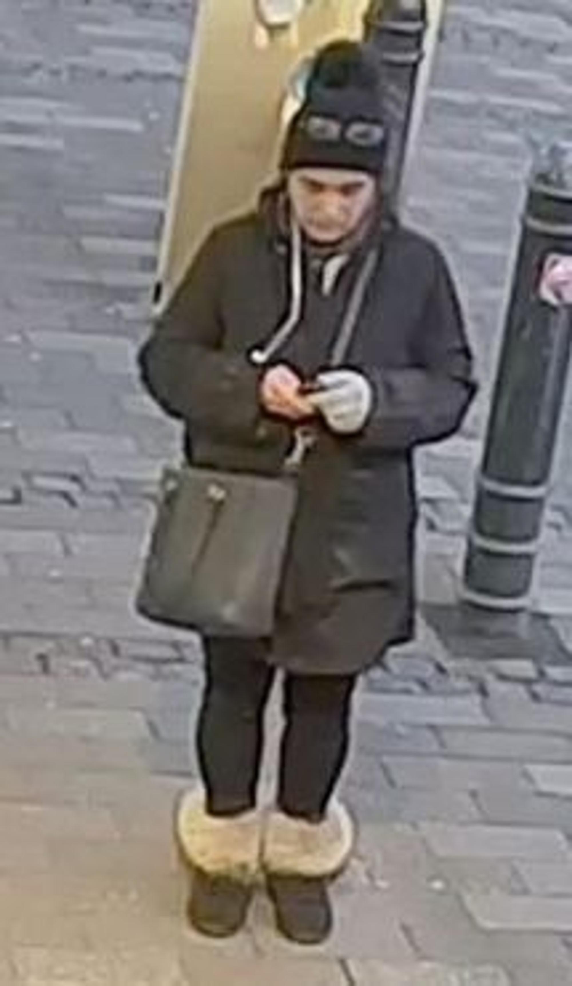 Frau mit schwarzem Mantel, Stiefeln mit Fell und schwarzer Mütze