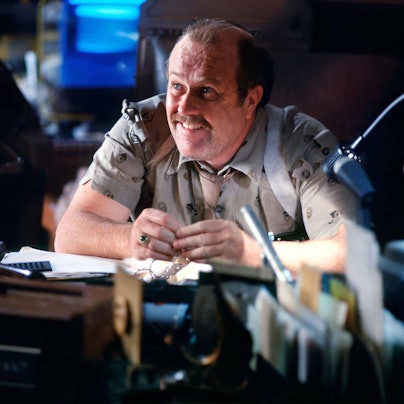 M. Emmet Walsh grinst als Polizeichef Bryant in Ridley Scotts „Blade Runner“ (1982) hinter seinem Schreibtisch.