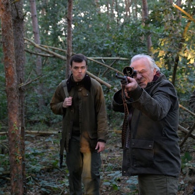Die drei Charaktere stehen im Wald. Dr. Albrecht Richtmann, der Chef der Kanzlei, zielt mit einem Jagdgewehr. Er steht mittig zwischen seinem Sohn Konstantin Richtmann und Daniel Pillokat, die beide der gleichen Anwaltskanzlei des Schützen arbeiten.