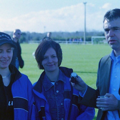 Zwei Frauen haben Andreas Rettig eine Armbanduhr geschenkt, er präsentiert sie in Richtung des Fotografen.