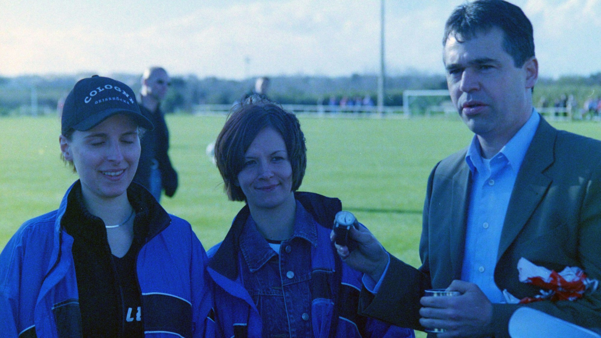 Zwei Frauen haben Andreas Rettig eine Armbanduhr geschenkt, er präsentiert sie in Richtung des Fotografen.