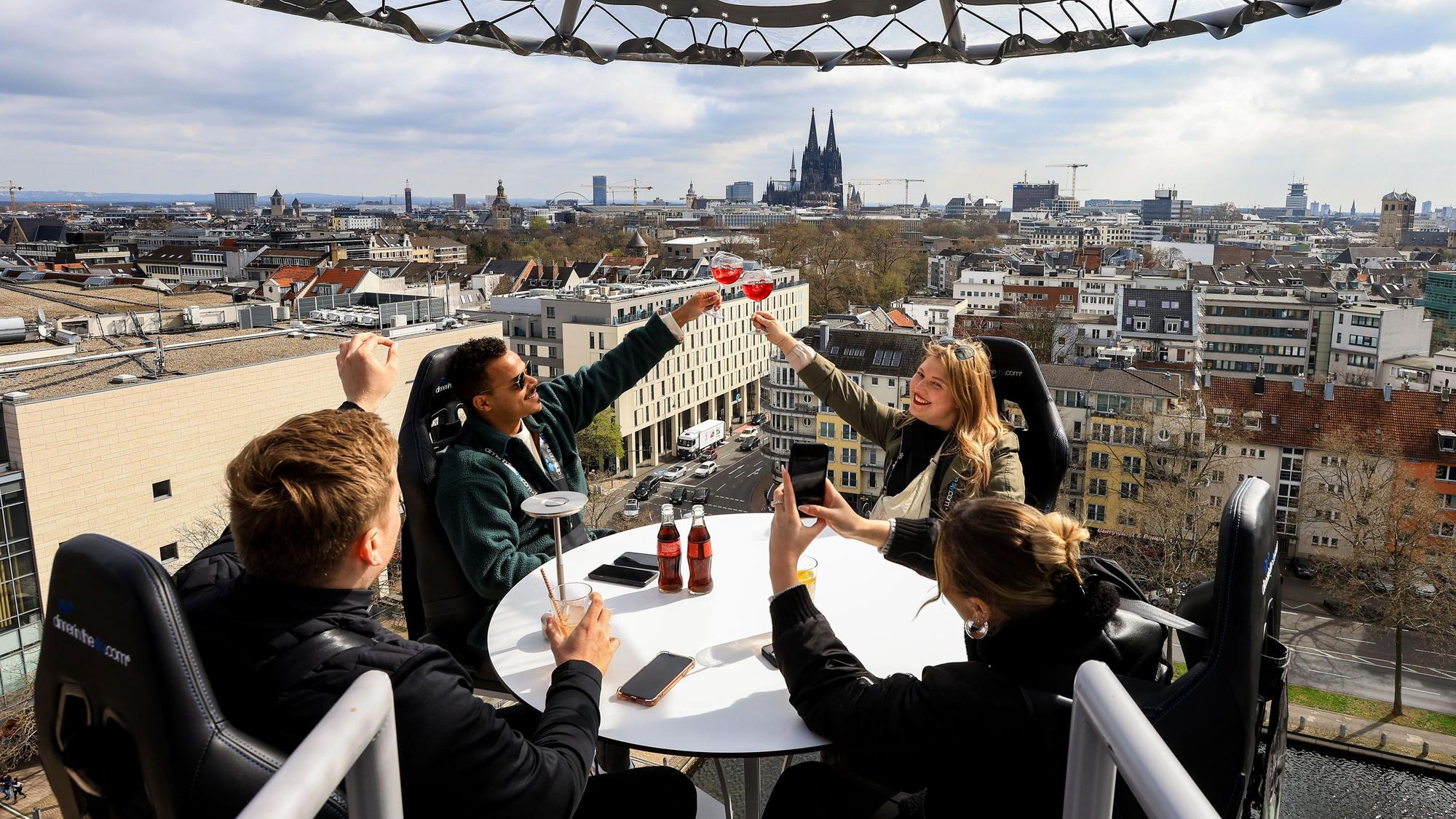 Menschen sitzen an einem Tisch auf einer Plattform in 50 Metern Höhe, im Hintergrund ist der Dom zu sehen