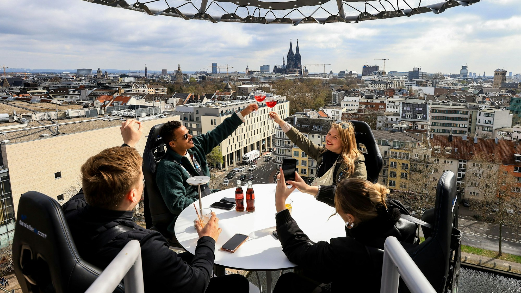 Menschen sitzen an einem Tisch auf einer Plattform in 50 Metern Höhe, im Hintergrund ist der Dom zu sehen