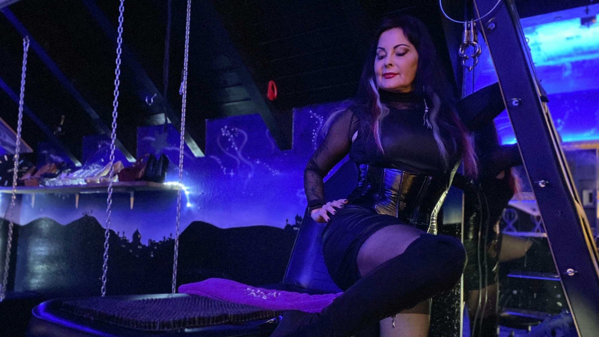 Saskia Jung steht in einem Studio voller Gerätschaften, das in blaues Licht getaucht ist.