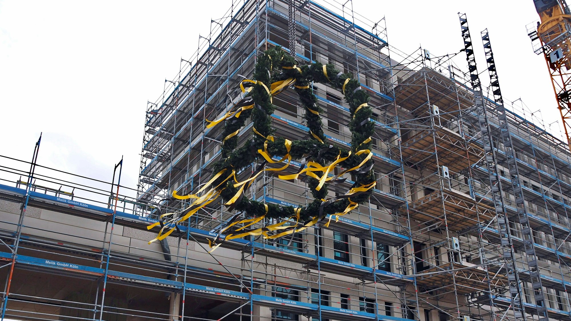 Der Rohbau der „Reiterstaffel Offices“ in der Gaedestraße. Im Vordergrund ist ein Richtbaum zu sehen.