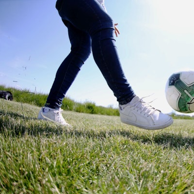 Eine Frau schießt einen Ball Richtung eines Ziels.