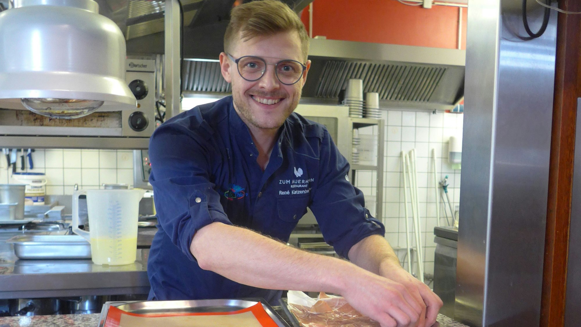 Zu sehen ist ein Koch in einer Küche.