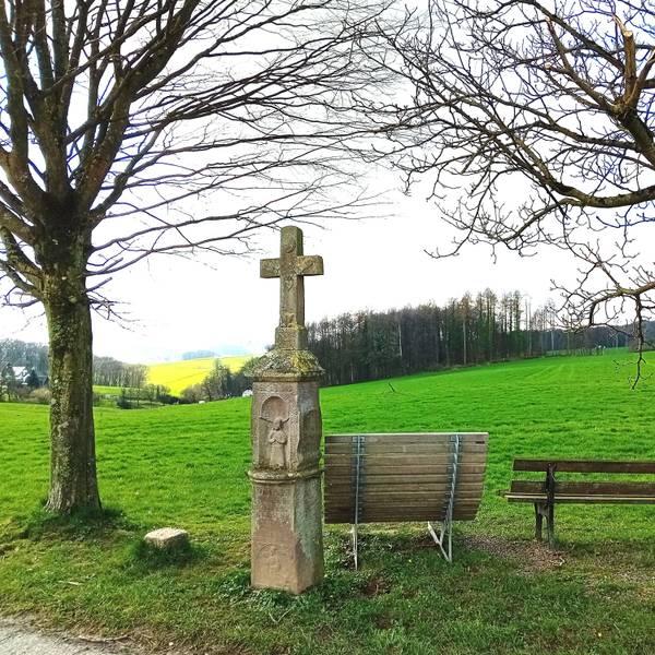 Ein Wegekreuz vor Panoramablick.