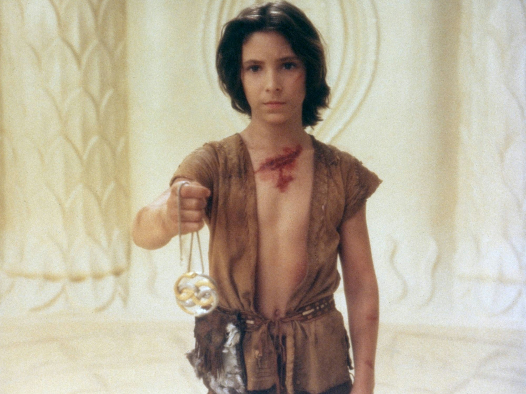 Noah Hathaway als Atreju in Die unendliche Geschichte. Er hält das „Auryn“ der Kindlichen Kaiserin in der Hand.