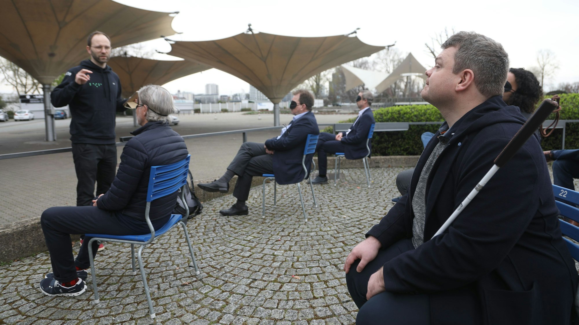 Das Bild zeigt FC-Legende Toni Schumacher mit einer Schlafbrille und Manuel Beck, Inklusionsberater der Stadt im Tanzbrunnen.