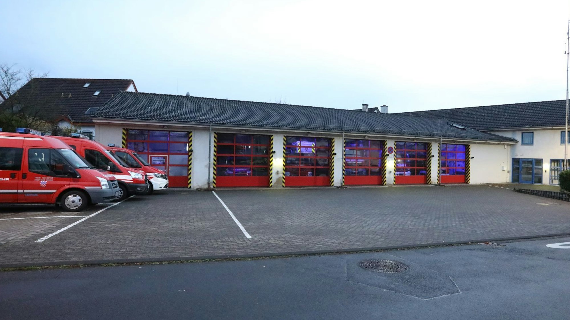 Einsatzfahrzeuge stehen neben der Feuerwache Bad Honnef, die roten Tore sind geschlossen.
