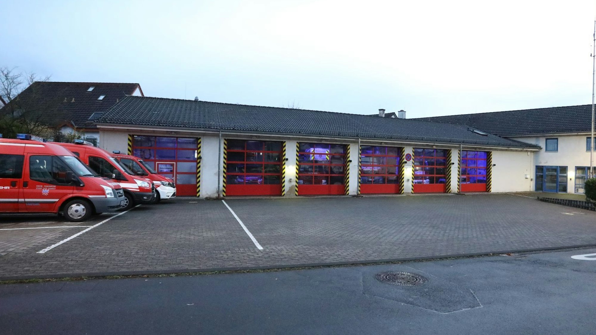 Einsatzfahrzeuge stehen neben der Feuerwache Bad Honnef, die roten Tore sind geschlossen.