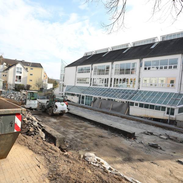 Ein Baucontainer und Maschinen stehen in einer Baustelle neben dem Rathaus.