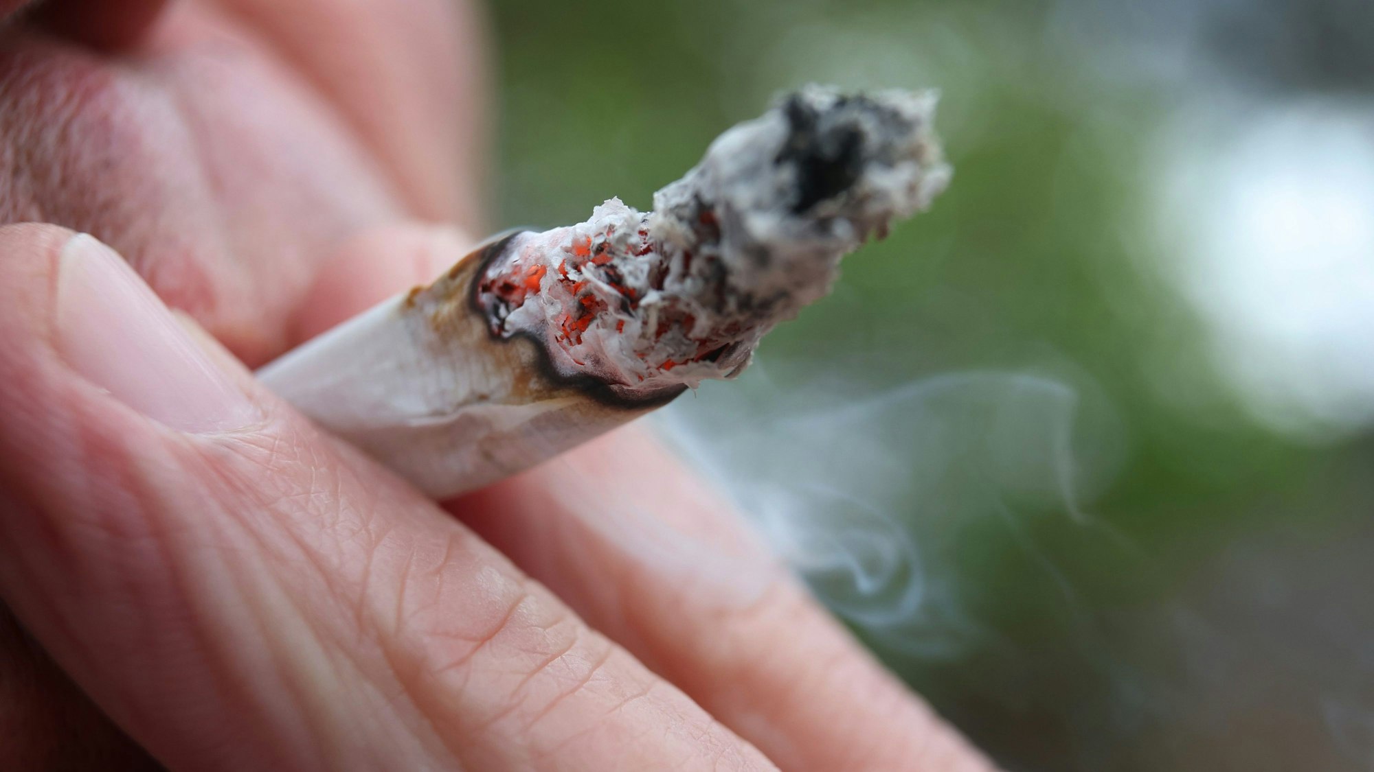 Eine Person raucht einen Joint.