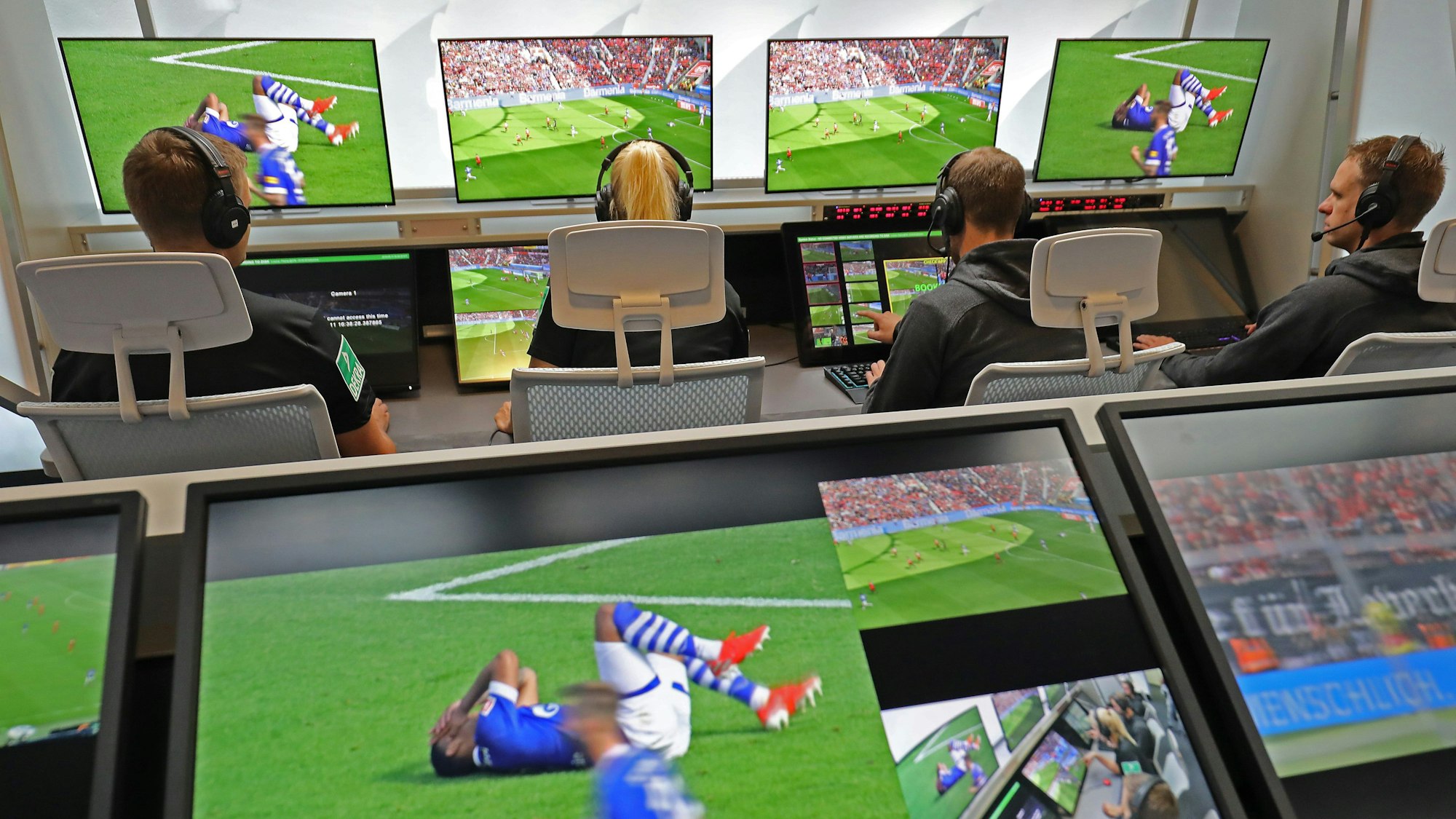 Fußball Schiedsrichter sitzen im Video-Assist-Center vor Monitoren.