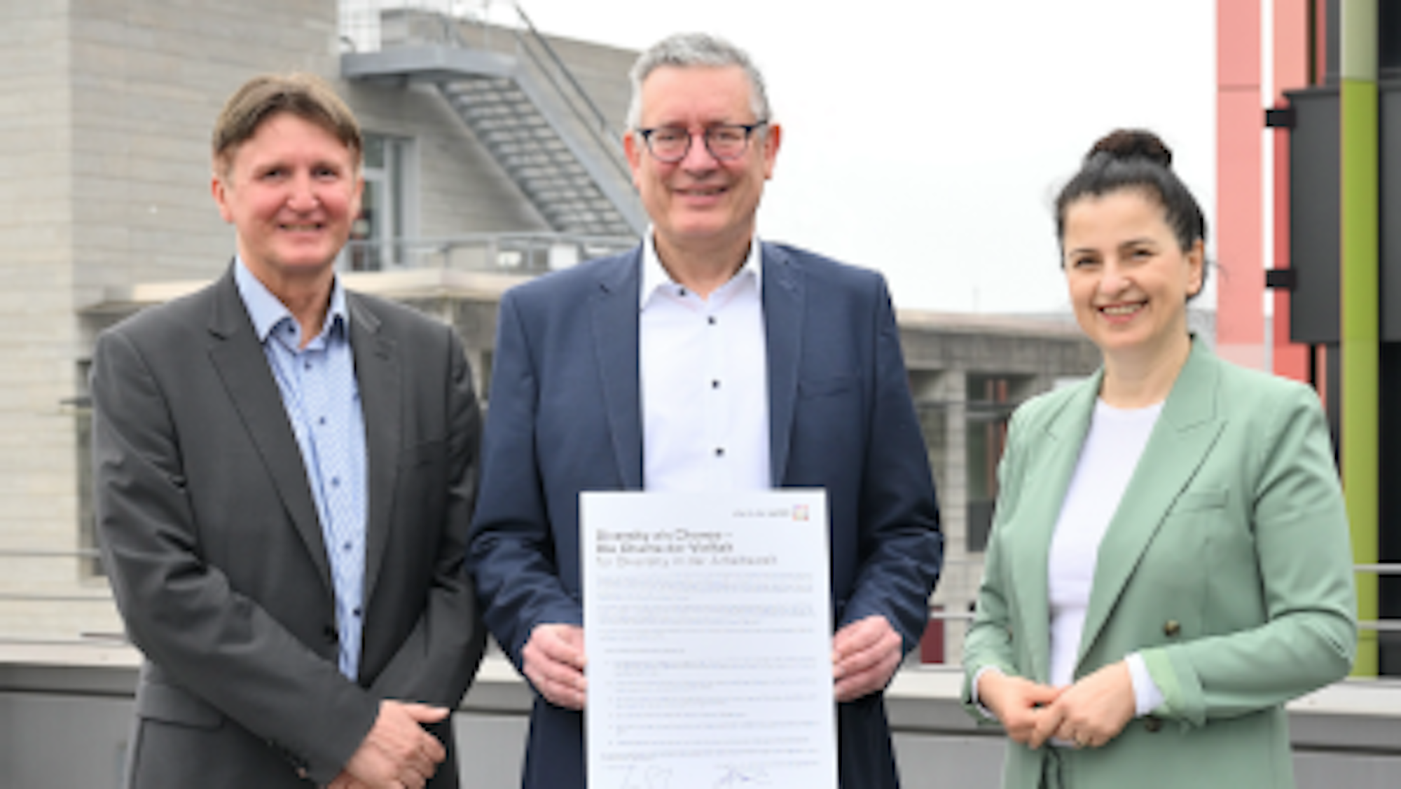 Drei Menschen stehen nebeneinander mit der Charta in der Hand. v.l.n.r.: Damian Grüttner (Kaufm. Direktor und Stellv. Vorstandsvorsitzender), Prof. Dr. Edgar Schömig (Ärztlicher Direktor und Vorstandsvorsitzender), Marina Filipović (Pflegedirektorin und Vorstandsmitglied)