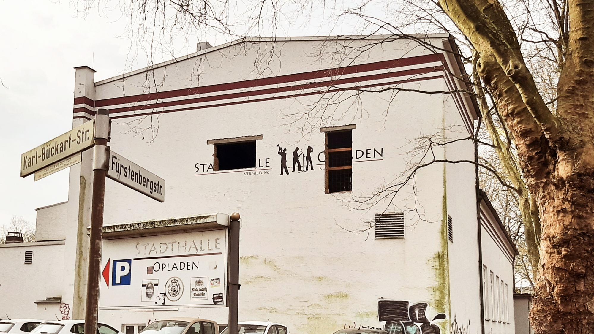 Seitenansicht der Stadthalle Opladen. In der Fassade klaffen zwei Löcher.