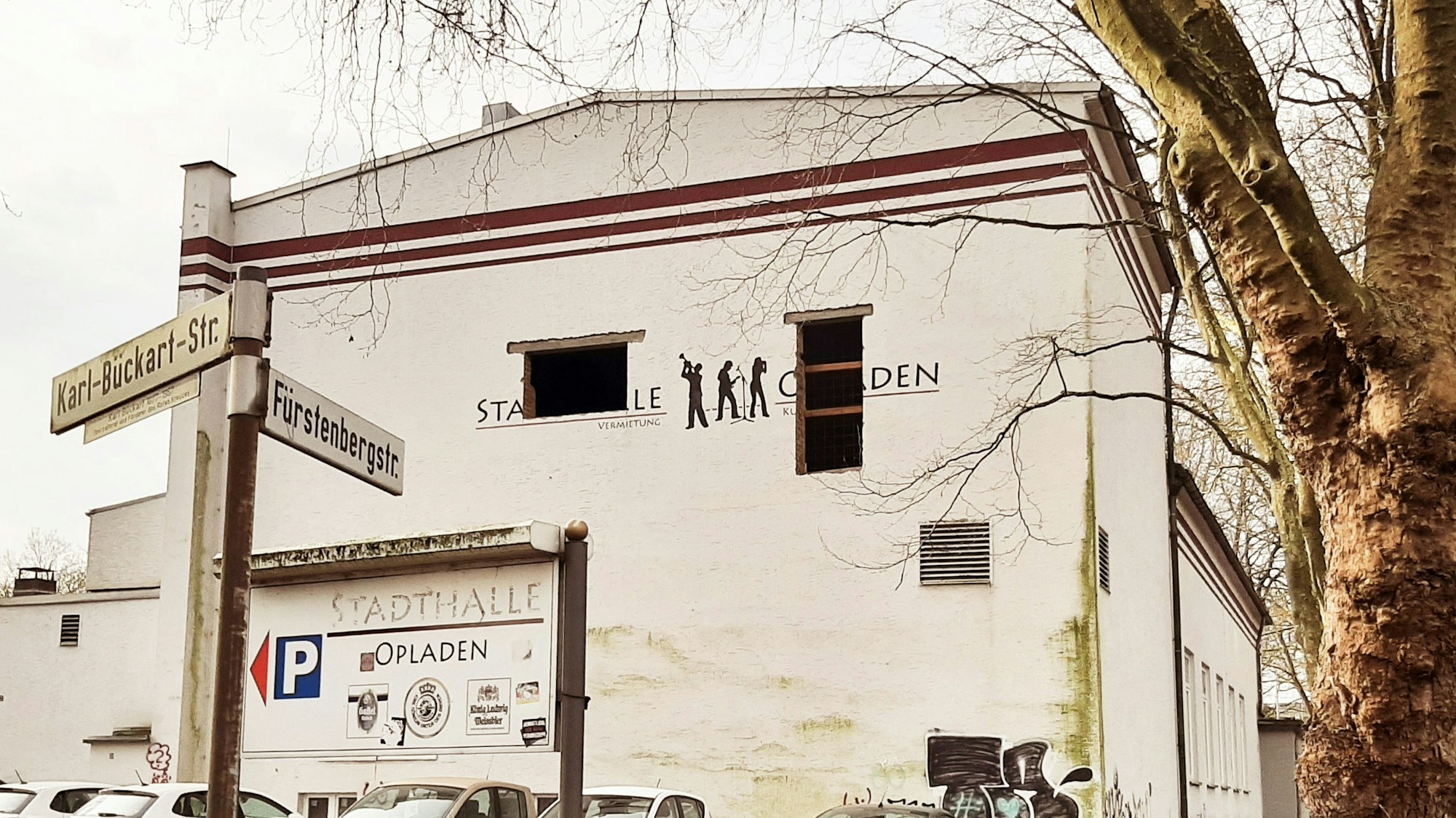 Seitenansicht der Stadthalle Opladen. In der Fassade klaffen zwei Löcher.