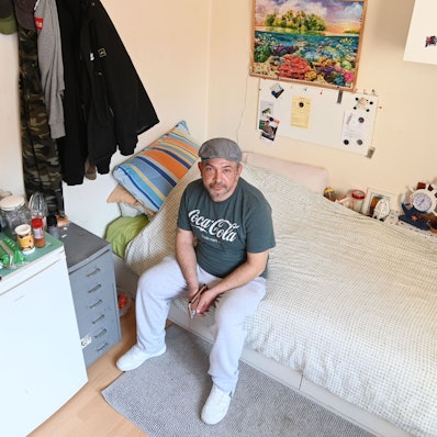 Christian Semerao sitzt auf dem Bett seines Zimmers in der Notschlafstelle für Drogensüchtige in der Cranachstraße.