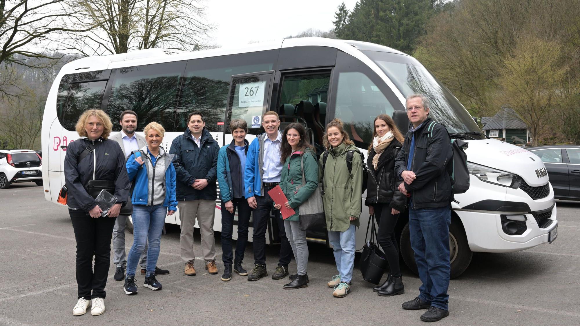 Menschen stehen vor dem Bergischen Wanderbus auf dem Parkplatz Am Rösberg in Odenthal-Altenberg.