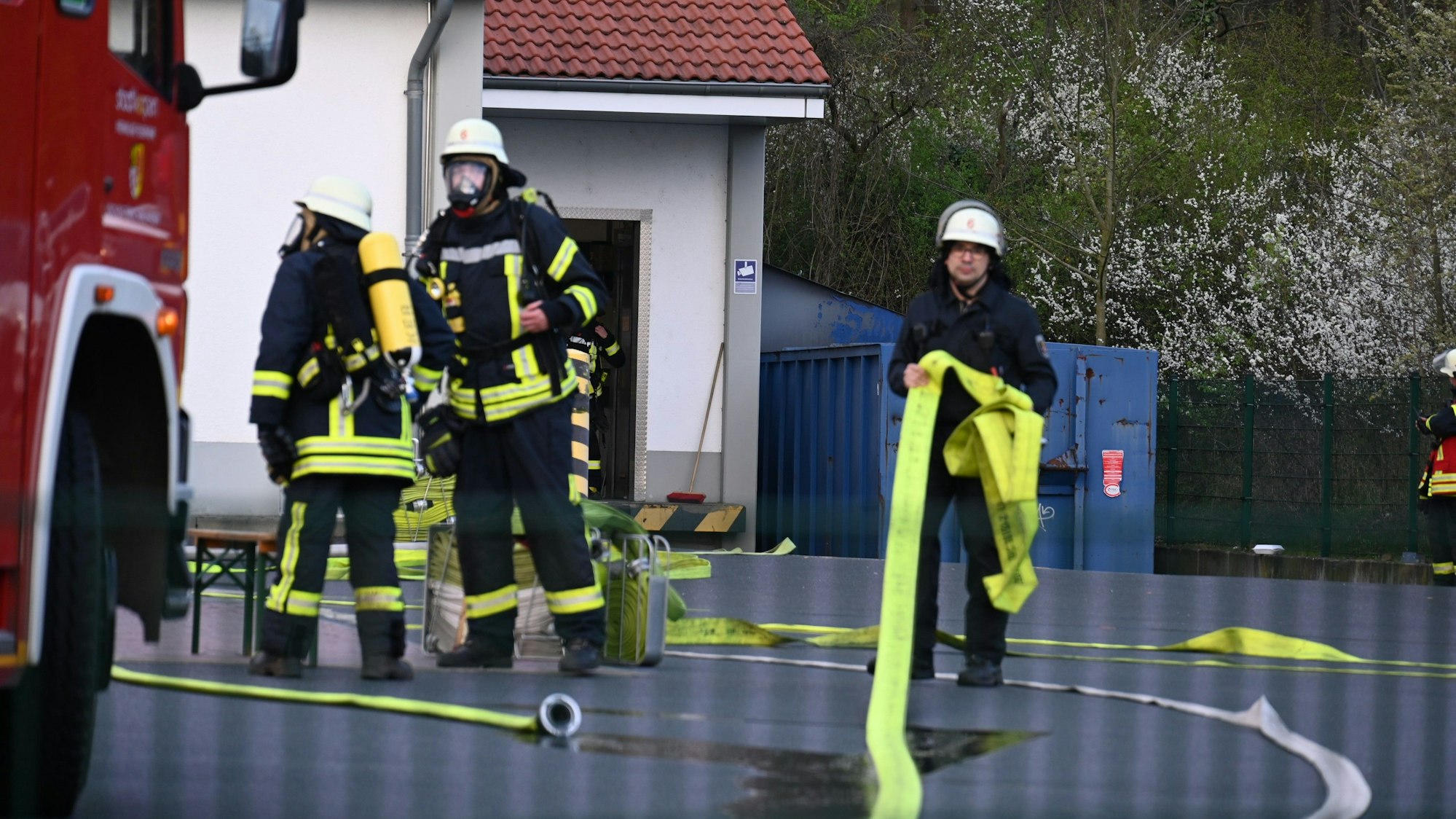 Es sind mehrere Feuerwehrleute zu sehen, die vor dem Discounter stehen.