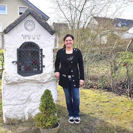 Medusa Knopf steht neben einer kleinen Kapelle.