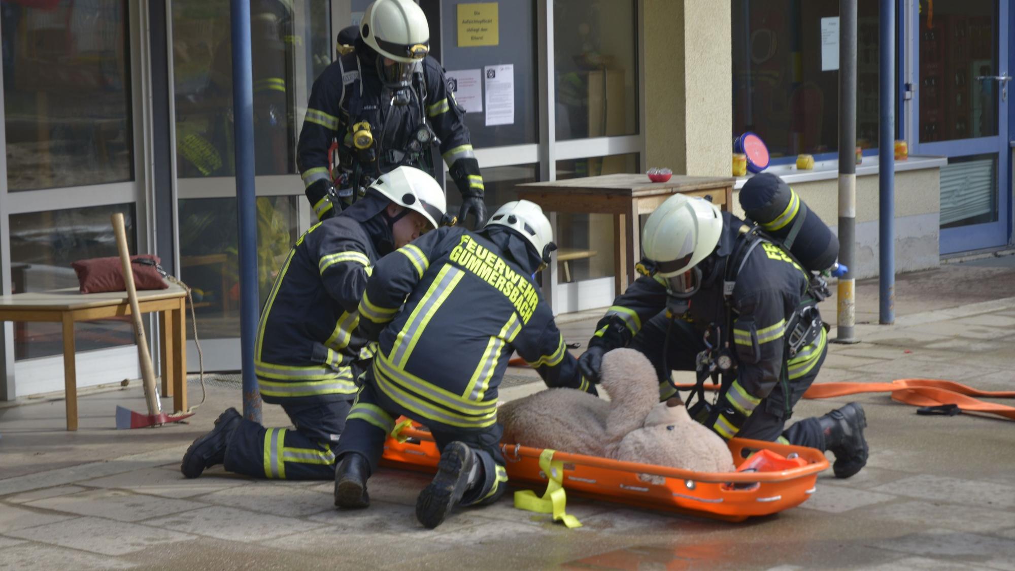 Feuerwehrübung an der Awo-Kindertagesstätte Lina-Ege. Feuerwehrmänner versorgen einen Teddybären.