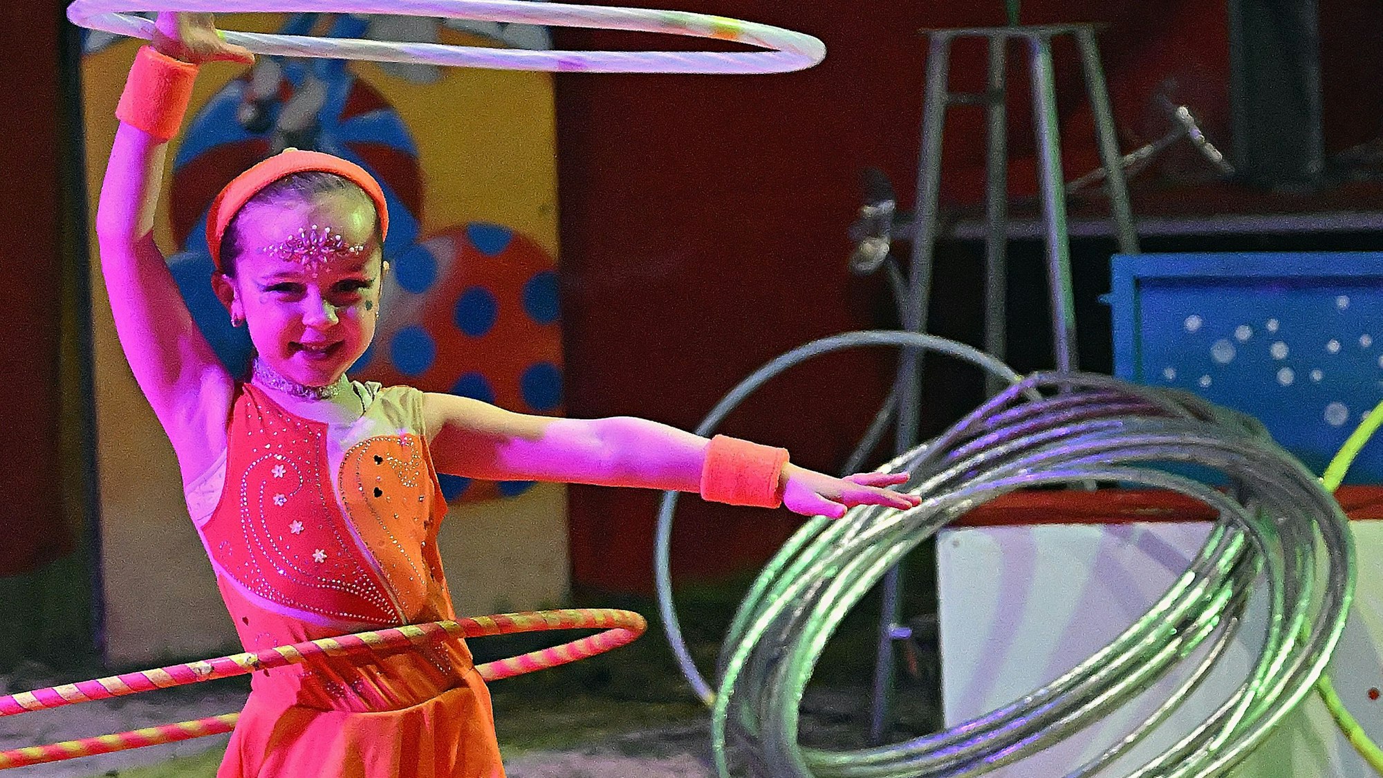 Ein Mädchen steht in der Manege und schwingt Ringe.