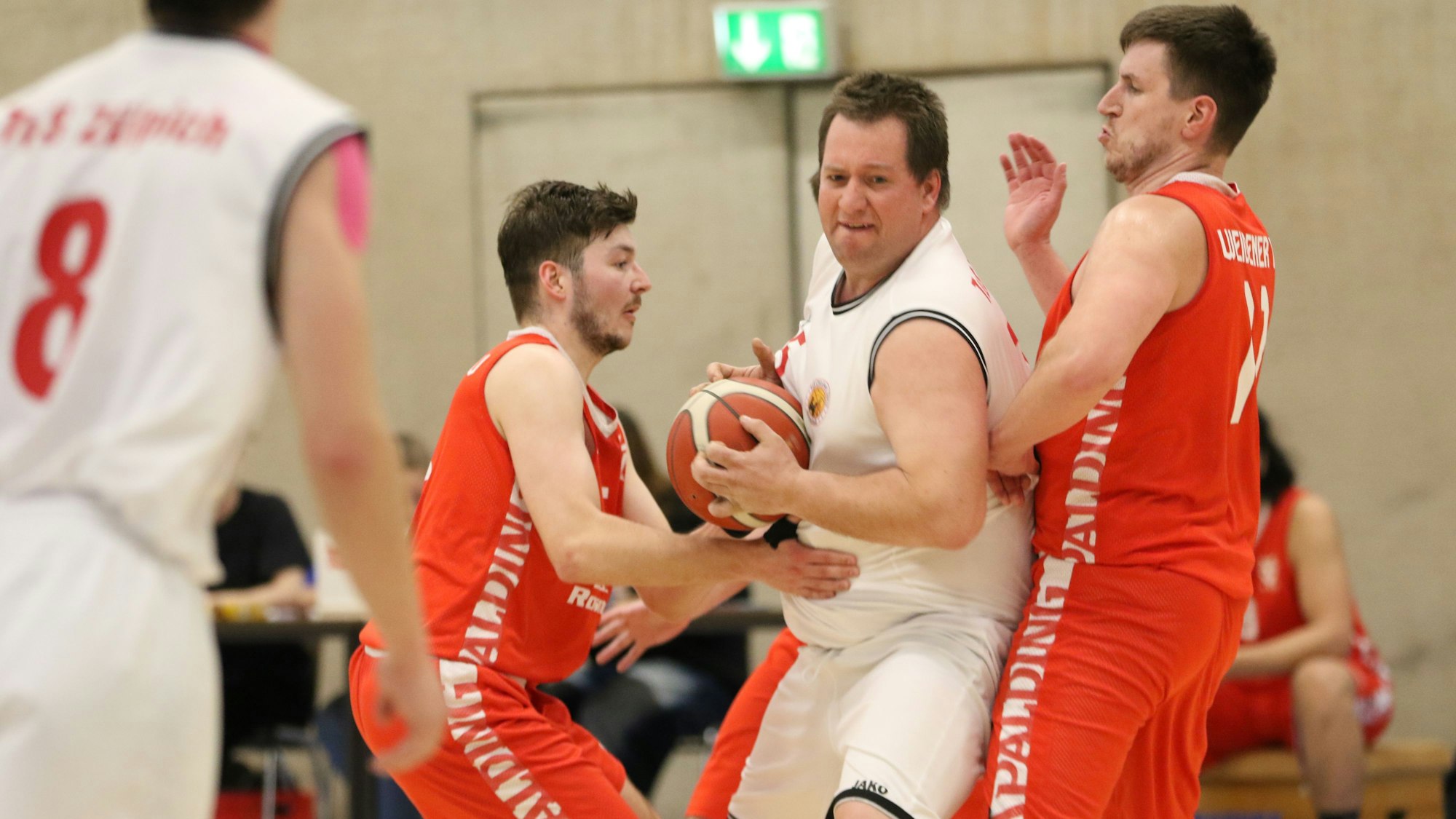 Das Bild zeigt Center Christian Antons, wie er sich gleich gegen zwei Gegenspieler durchsetzt.