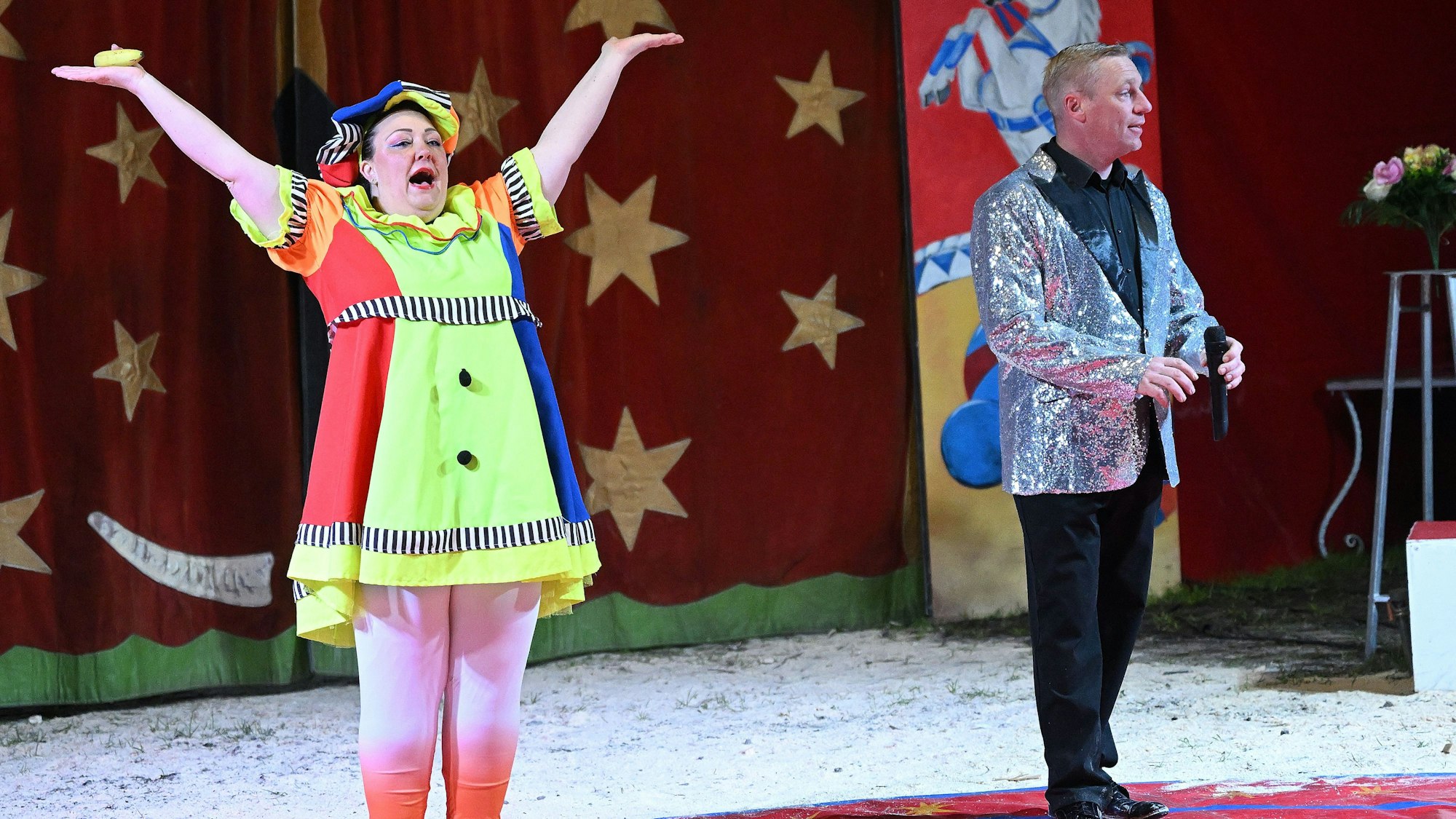 Eine Clownin steht in der Manege.