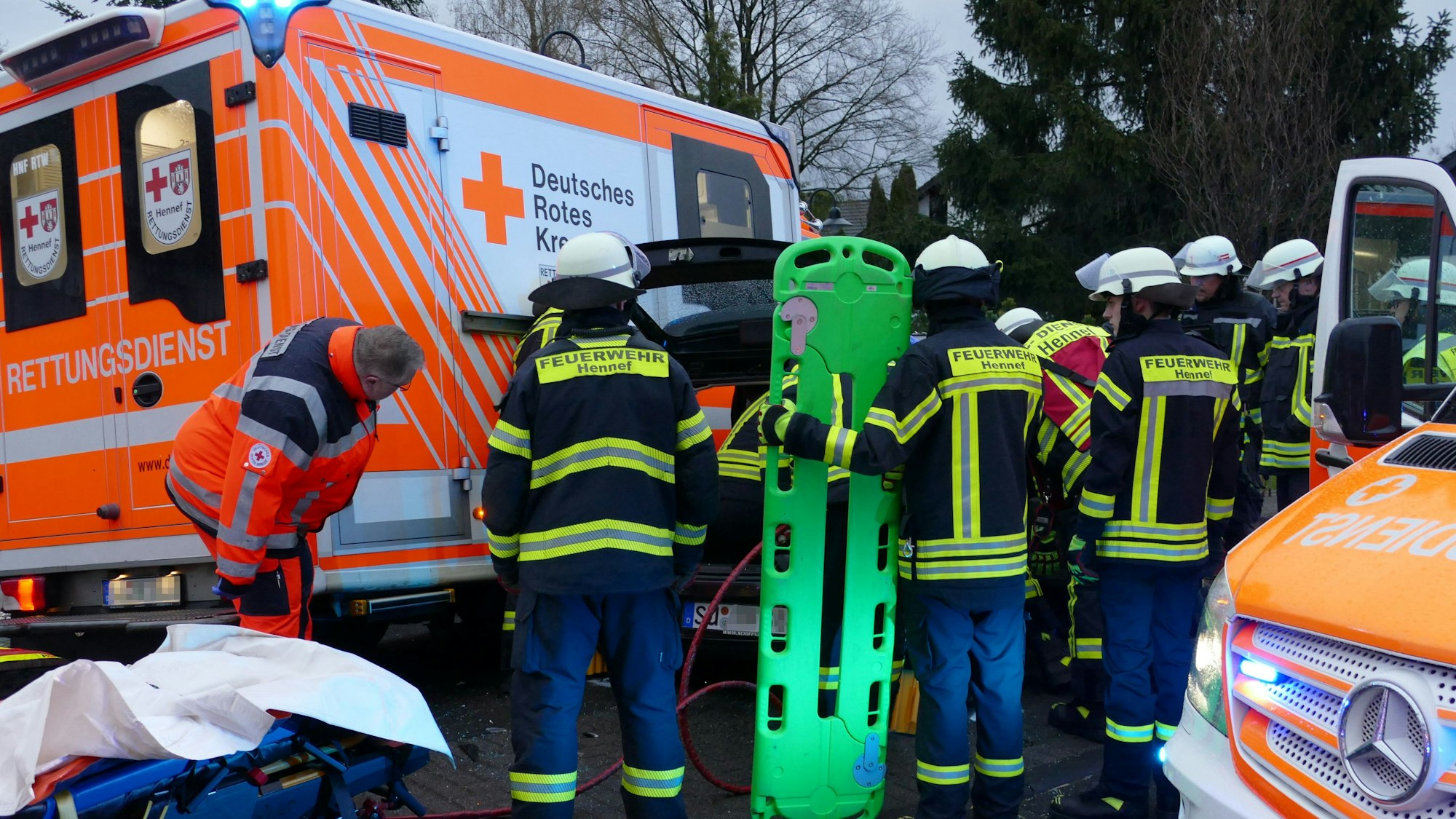 Feuerwehrleute stehen um ein Auto herum.