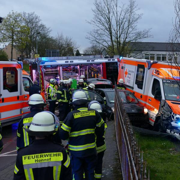Zwei Autos und ein Rettungswagen haben einen Zaun durchbrochen.