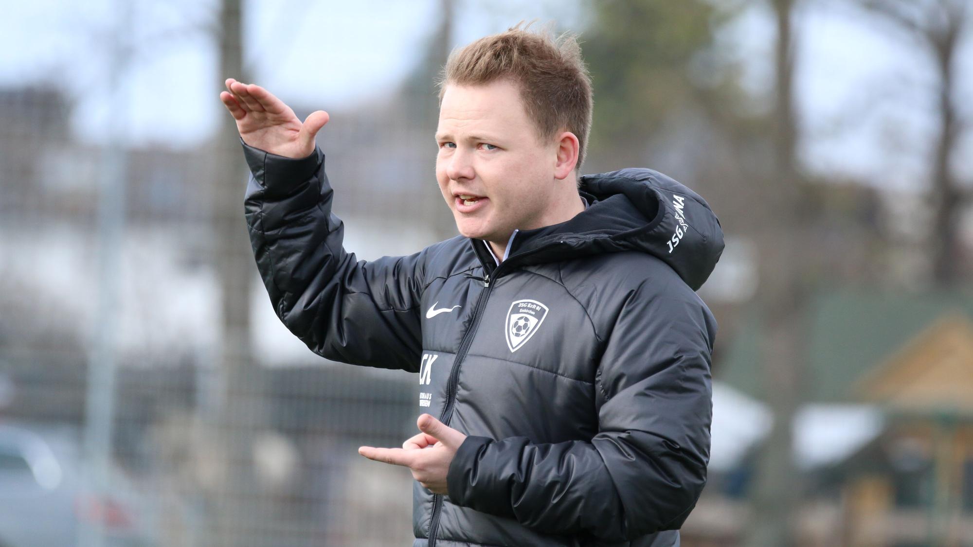 Das Bild zeigt Trainer Chris Kockerols, der mit seinen Händen seinem Team eine taktische Anweisung gibt.