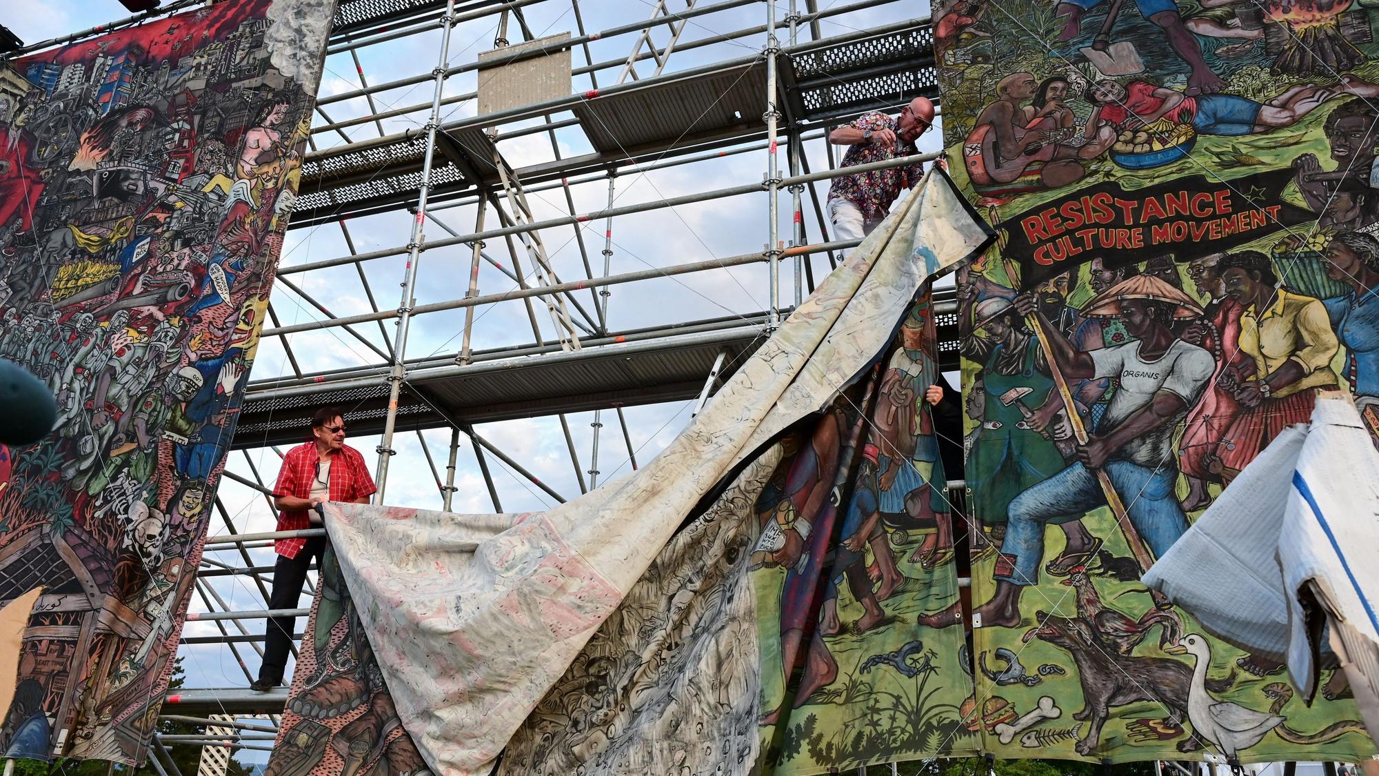 Documenta-Mitarbeiter bauen das umstrittene Großbanner „People's Justice“ nach Antisemitismus-Kritik ab.