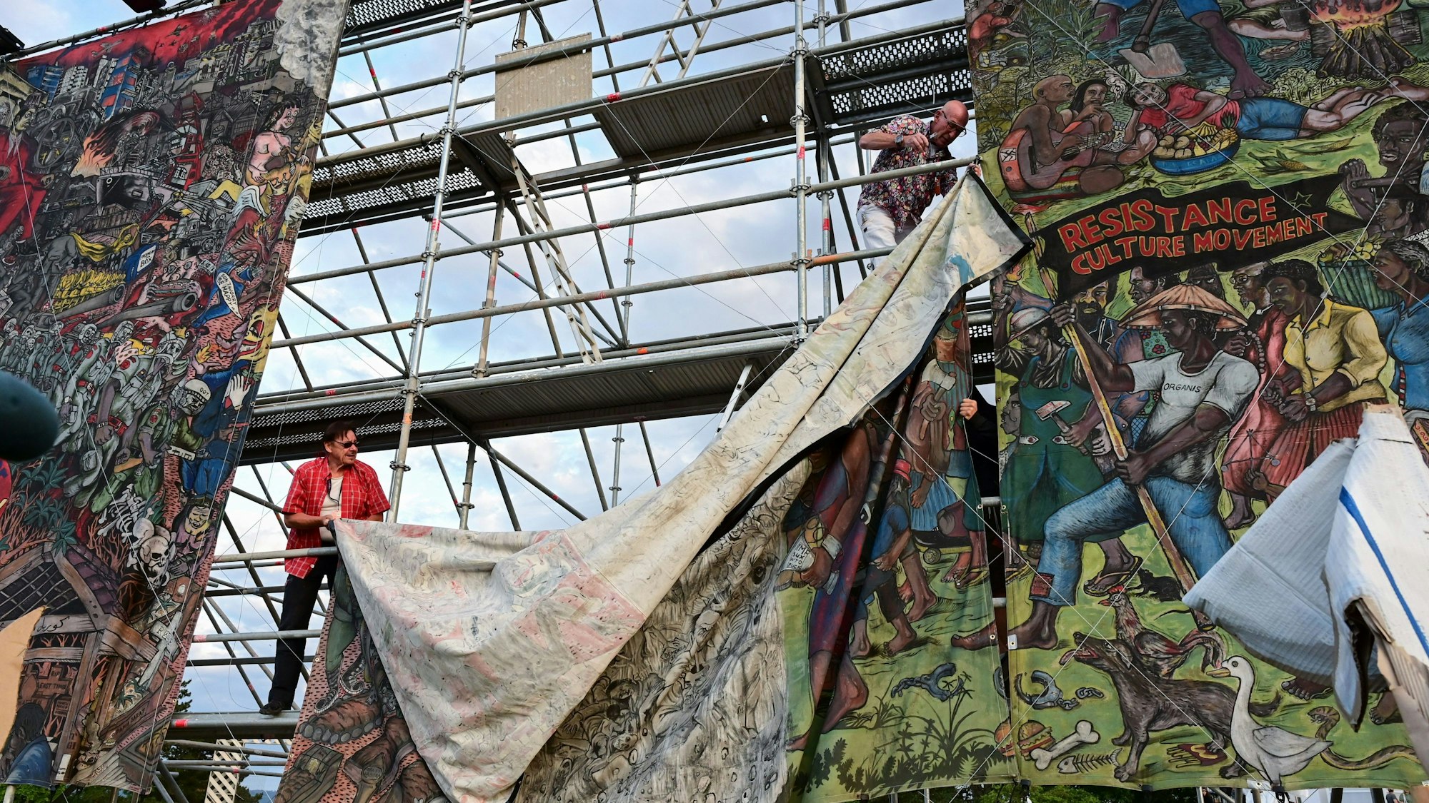 Documenta-Mitarbeiter bauen das umstrittene Großbanner „People's Justice“ nach Antisemitismus-Kritik ab.