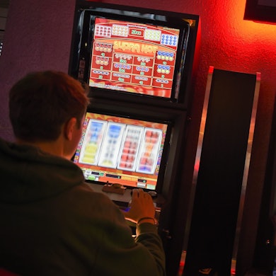 Ein Mann sitzt an einem Glücksspielautomaten