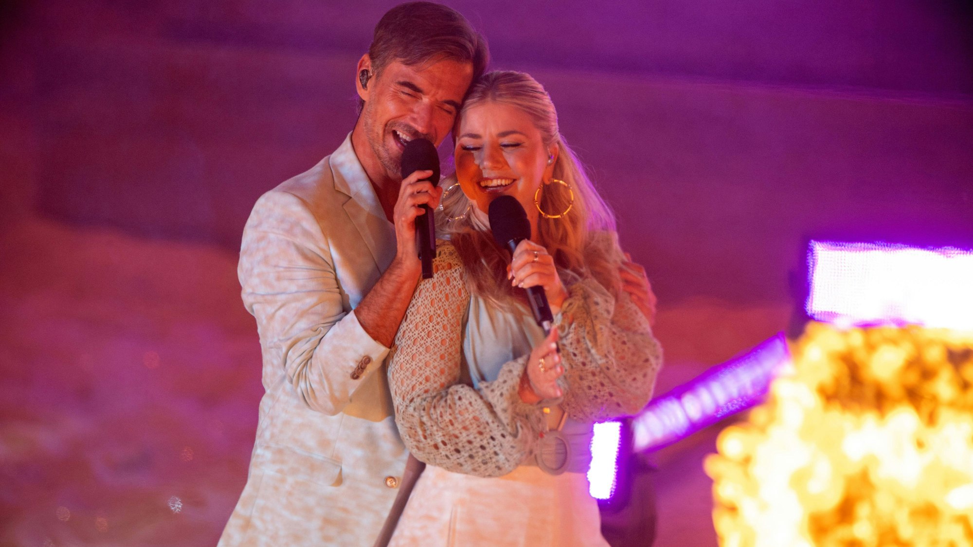 Florian Silbereisen und Beatrice Egli kuscheln auf der Bühne.