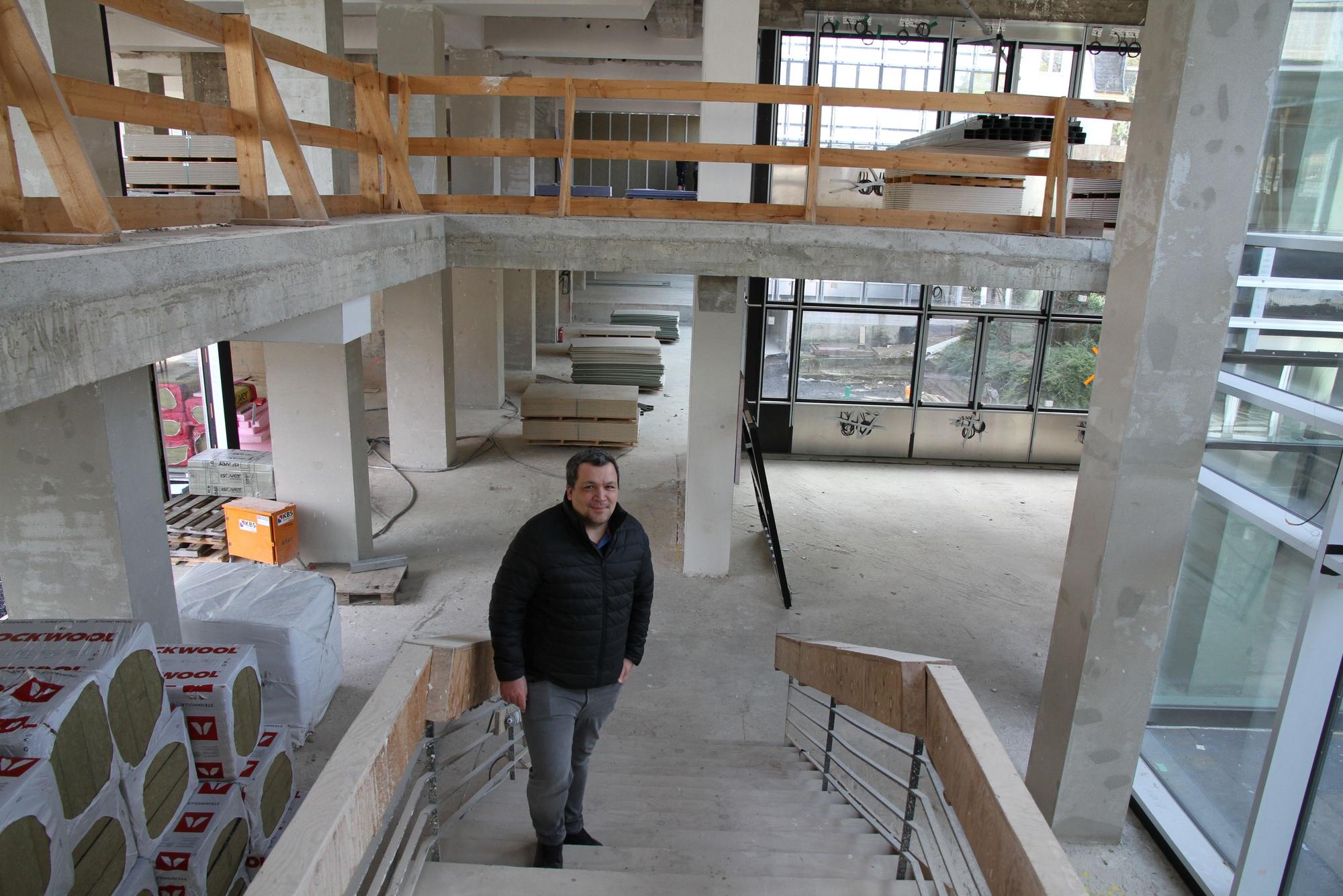 Ein Mann steht in einem Treppenhaus, das gerade saniert wird
