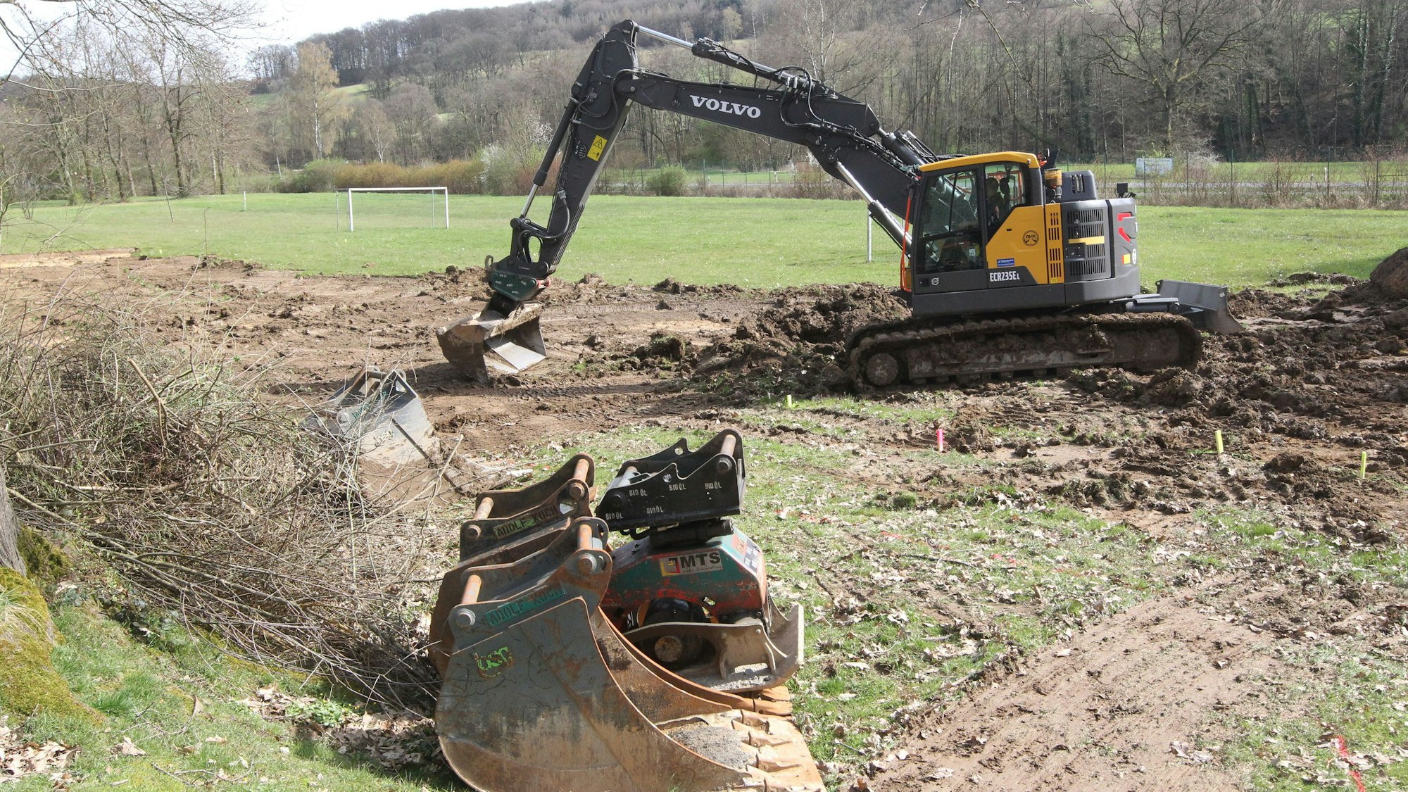 Ein Bagger steht auf einer Wiese.
