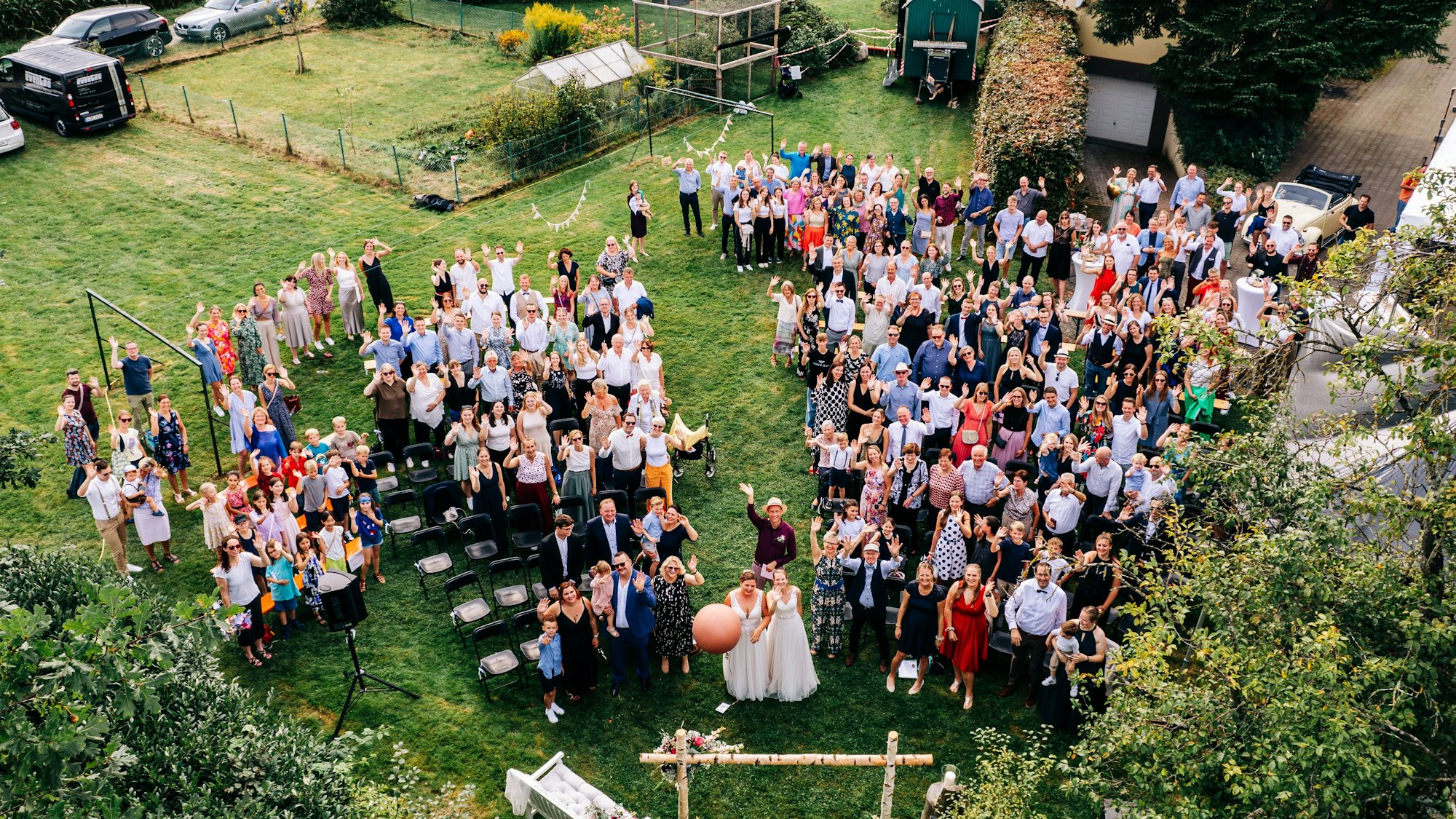 Menschen stehen in einer Traube und strecken die Hände in die Luft.