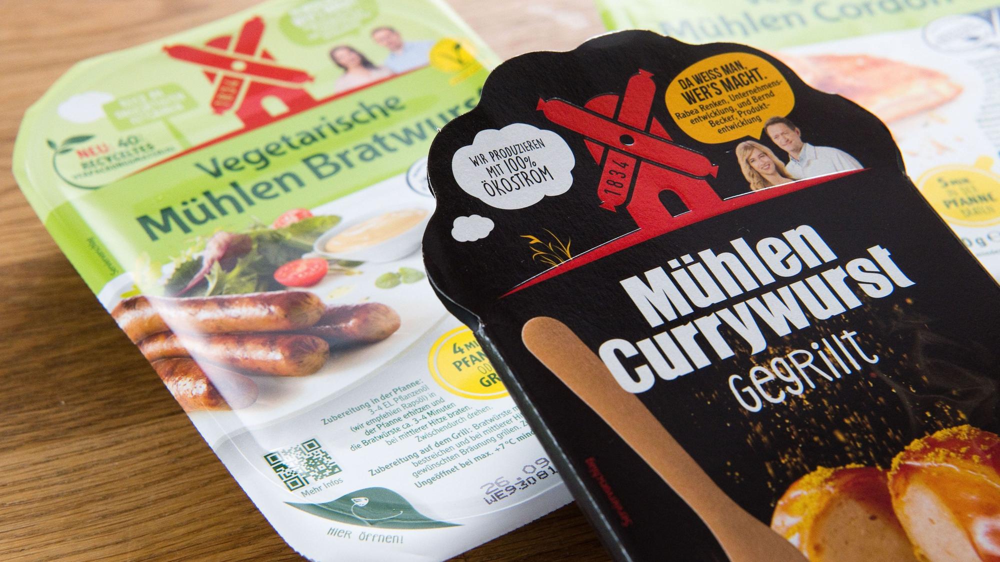 Die „Mühlen Currywurst - gegrillt“ vom Hersteller Rügenwalder Mühle liegt mit vegetarischen und veganen Produkte auf einem Tisch.