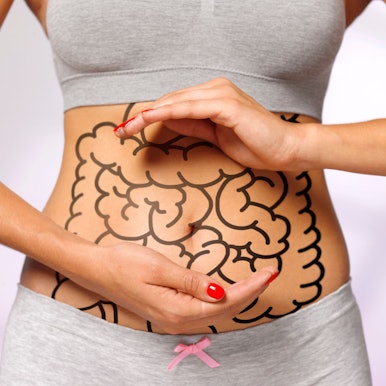 Eine Frau hält schützend ihre Hände über einen eingezeichneten Darm Foto: Getty Images/The Image Bank RF