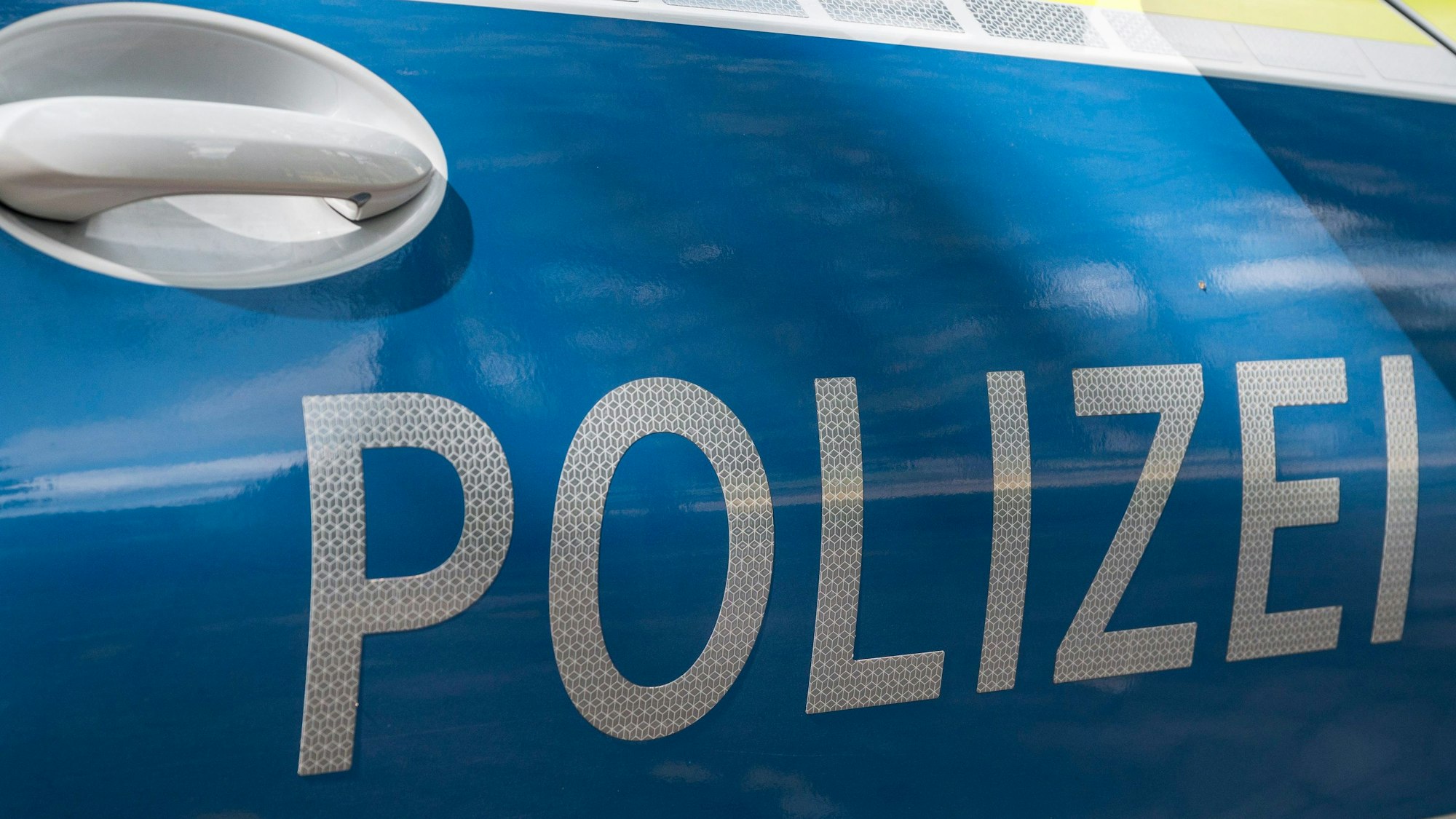 Das Foto zeigt den Schriftzug "Polizei" auf einem Streifenwagen.