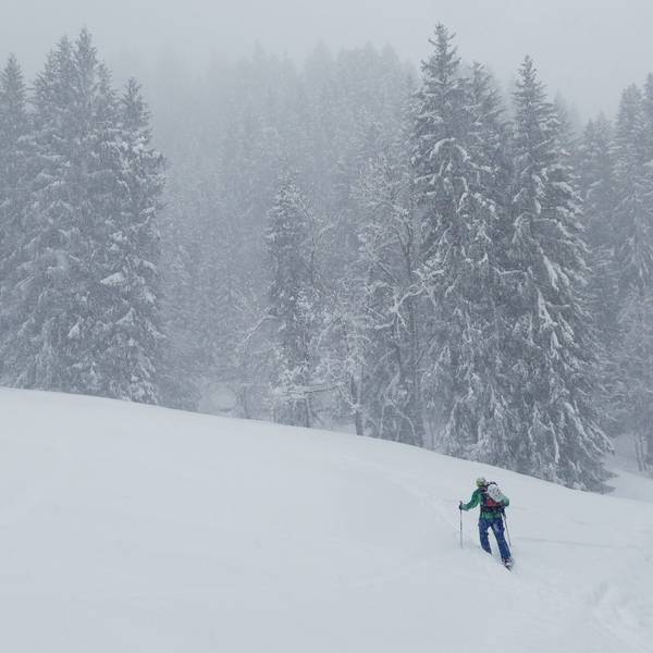 Ein Skitourengeher steigt durch viel Neuschnee einen Berg hinauf. (Symbolbild)