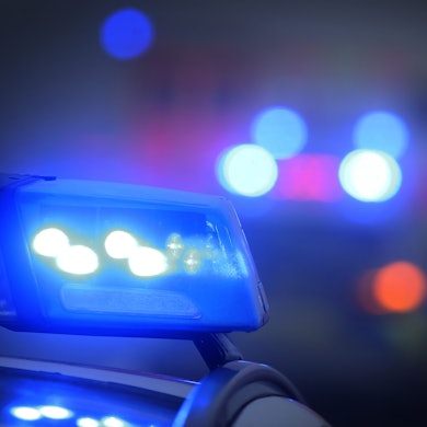 Ein Polizeiauto mit eingeschaltetem Blaulicht steht an einer Einsatzstelle.