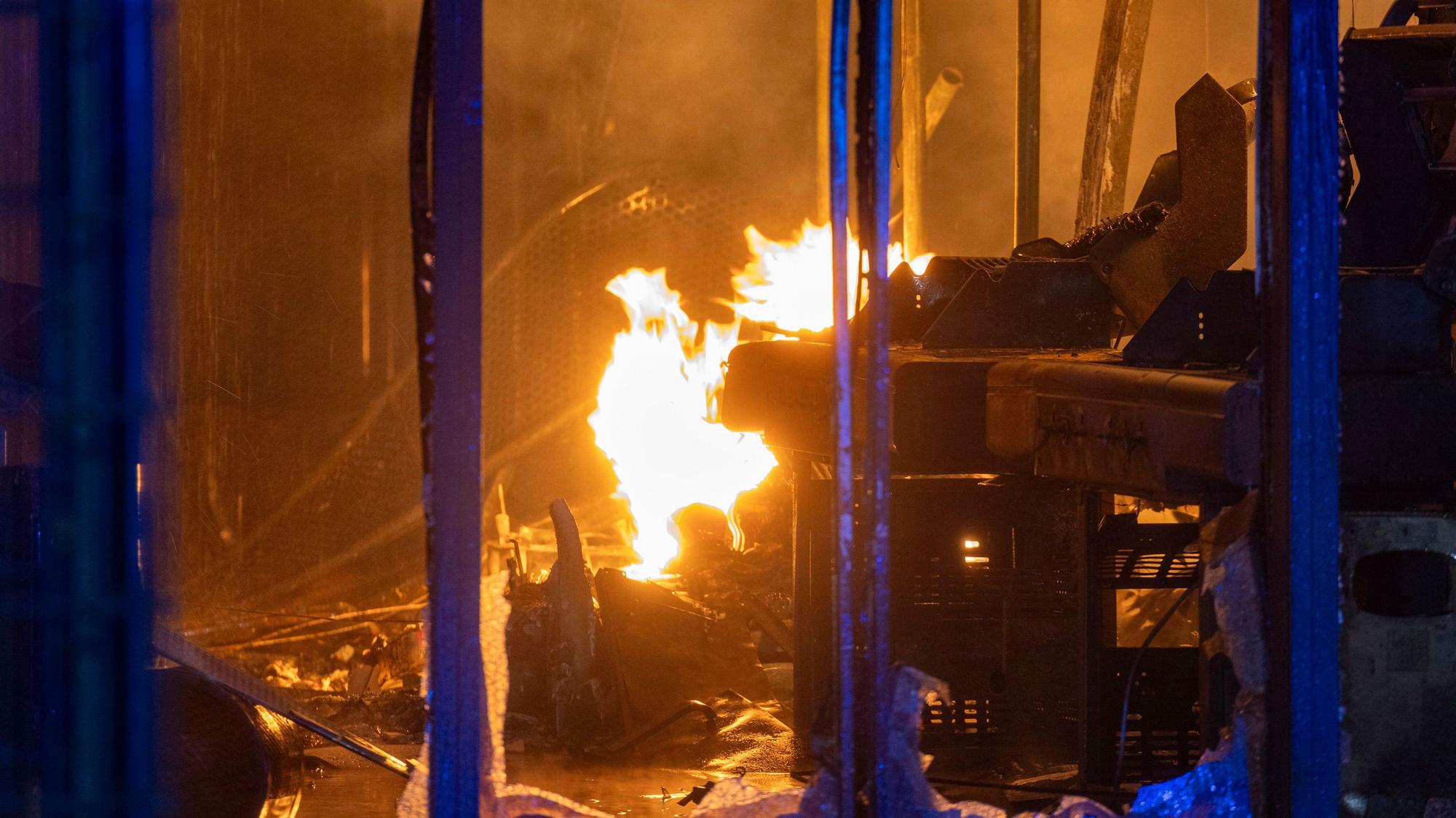Im Inneren des Gebäudes sind bei einem Großbrand in einem Baumarkt Flammen zu sehen.