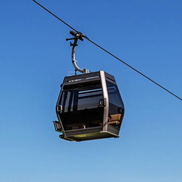 Die Kabine einer Seilbahn vor blauem Himmel.